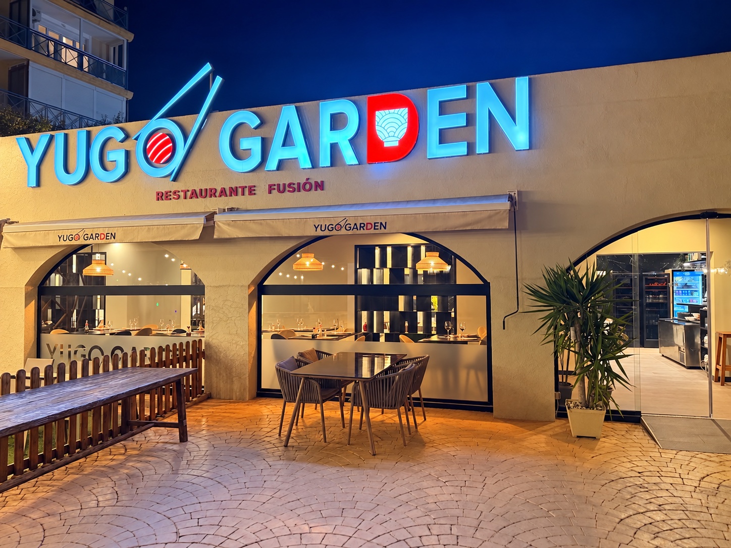 Yugo Garden’s warmly lit restaurant and terrace at night